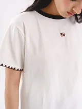 Remera de algodón azul marino, con cuello redondo y detalles en color blanco. Presenta mangas cortas con terminación bordada a contratono y logo bordado pequeño en el frente.