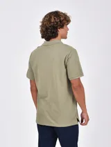 Remera tipo chomba de manga corta, color negro, con cuello y tapeta de botones. Presenta un pequeño logo bordado en el pecho.