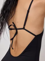 Malla entera de natación color negro con estampado de motivos playeros en blanco, con breteles finos y corte de pierna alto.