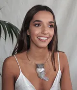 Collar rígido plateado con dije colgante de nácar irregular con engarce metálico.