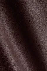 Pollera tubo de cuero sintético color marrón oscuro, de largo hasta la rodilla, con tajo frontal y cierre oculto en la parte trasera.