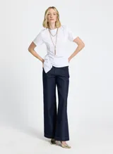 Remera blanca de punto con cuello redondo, mangas cortas, frunce lateral y bajo asimétrico.