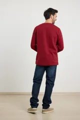 Remera de manga larga en tejido elastizado, color azul, con cuello tipo camisa, cartera con botones y detalles en eco gamuza en la base del cuello y la cartera.