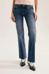 Pantalón jean de corte bootcut, color azul con lavado y efecto desgastado, de tiro medio y con bordes deshilachados en el bajo.
