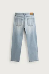 Jeans regular fit de mezclilla celeste con efecto lavado, corte recto y diseño clásico de cinco bolsillos. Cuenta con cierre frontal de botones.