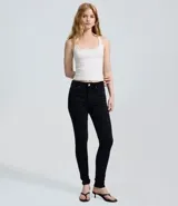 Pantalón skinny de tiro alto confeccionado en denim con elastano. Presenta cierre frontal con botón y cremallera, trabillas para cinturón y bolsillos funcionales tanto en el frente como en la parte posterior.