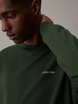 Buzo verde oscuro de algodón y poliéster con cuello redondo, puños y bajo acanalados. Presenta el logo de Calvin Klein bordado en pequeño en el pecho.