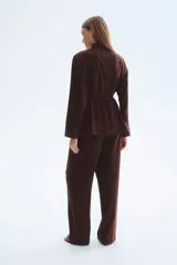 Blazer oversized bordó de cuello alto, con hombreras, bolsillos delanteros ribeteados, abertura en los puños y cinturón fino incorporado con hebilla metálica.