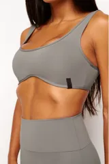 Top deportivo gris con escote cuadrado, breteles anchos y calce ajustado. Incluye forro interno y apertura para almohadilla removible.