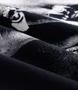 Remera de algodón negra de corte relajado, con cuello redondo, mangas cortas y estampa frontal de cruz con lettering y diseño en la espalda.