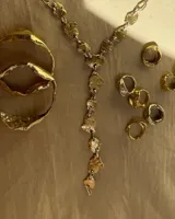 Brazalete rígido de diseño orgánico con textura irregular y acabado brillante, elaborado artesanalmente en metales nobles.