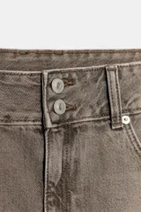 Falda corta de denim color marrón grisáceo, tiro bajo, con cierre frontal de doble botón y bajo deshilachado.