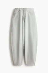 Pantalón de jean color gris claro, de tiro alto y diseño baggy con corte holgado en la cadera y piernas anchas estilo balloon.