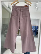 Pantalón de jean color rosa viejo, de corte recto y tiro alto, con costuras verticales decorativas en el frente y cierre de botón metálico.
