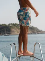 Short de baño con estampado de hojas en tonos azul, beige y rojo.