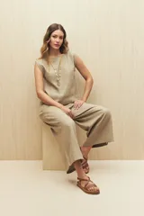 Pantalón de lino color negro, de tiro alto y corte wide leg con pierna ancha y caída fluida.