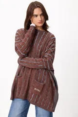 Sweater de tejido artesanal con diseño de rayas verticales en tonos camel y beige, corte holgado, cuello redondo y puños altos ajustados.
