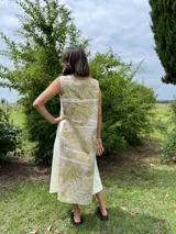 Vestido midi de corte evasé con estampado de hojas en tonos verdes y beige.