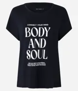 Remera deportiva negra de viscosa, corte amplio, mangas cortas y estampado frontal con la frase "Connect your mind, body and soul".
