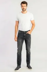Pantalón jeans slim de hombre en color negro con lavado oscuro y efecto deslavado sutil. Presenta corte ajustado, tiro medio, bolsillos clásicos y cierre frontal con botón y cremallera.