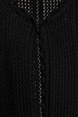 Chaqueta de punto calado con diseño pointelle, cuello redondo y manga larga. Presenta cierre frontal con corchete oculto y terminaciones con detalle de ondas en puños y ruedo.