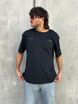 Remera negra de corte oversize con estampado en la espalda que dice 'REAL ADVENTURE STORIES OF THE EAST'.