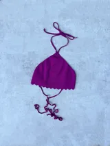 Top de punto halter color fucsia, tejido de hilo con borde festoneado en la parte inferior. Se ata en la nuca y en la espalda.