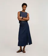 Falda midi de denim en corte evasé, con abertura frontal y cinturón fino de cuero sintético incluido. Confeccionada en algodón, presenta un diseño versátil y moderno.
