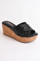 Sandalia color beige con plataforma de corcho y tiras cruzadas de cuero.