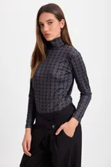 Polera de cuello alto y manga larga con estampado geométrico de rombos en tonos bordó y detalles en blanco.