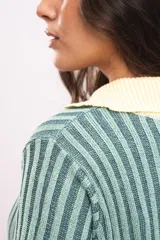 Vestido corto de tejido de punto acanalado en color verde menta, con cuello polo y solapas en color amarillo claro, de manga corta y corte recto.