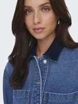 Campera de denim de manga larga, con cuello clásico, cierre frontal con botones y dos bolsillos delanteros con solapa.