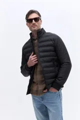 Campera puffer de nylon color beige, con diseño minimalista, cuello alto, cierre frontal y puños elásticos. Presenta logo de la marca bordado en el pecho.