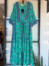 Kimono largo con estampado de cachemir en tonos azul, naranja y rosa. Tiene corte cruzado, mangas anchas y largo hasta los tobillos.