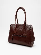 Cartera de mano estructurada de cuero vacuno rojo, con doble asa superior y detalles de charol en la parte superior. Cuenta con cierres metálicos y apliques decorativos laterales con hebillas.