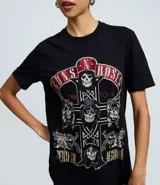 Remera de algodón color negro con estampa frontal de la banda Guns N' Roses y aplicación de strass. Presenta cuello redondo y mangas cortas.