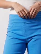 Pantalón capri blanco de gabardina elastizada. Pretina ancha elastizada, delantera con bolsillos simulados y trasera con bolsillos aplicados.