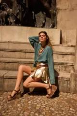 Minifalda de cuero color marrón oscuro, con fajón en la cintura y volados en el ruedo.