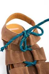 Sandalias de cuero color marrón, con suela track marrón oscura y cordones estilo marinero en color verde azulado que cruzan la capellada.