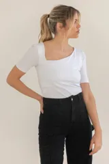 Remera blanca de mangas cortas con escote asimétrico cuadrado.