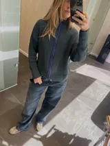 Campera tejida con textura vanizada a rayas verticales en color lila y negro, con cierre frontal y cuello alto.