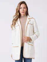 Chaqueta de silueta estructurada y calce recto, confeccionada en tejido jacquard con relieve floral. Presenta cuello con solapas, frente abierto y dos bolsillos de parche frontales. Se destaca por sus vivos a contratono que bordean las solapas, los bolsillos y las costuras horizontales, además de contar con tajos laterales en el ruedo.