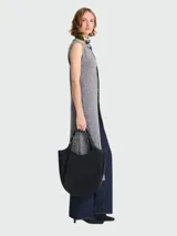 Bolso tote de gran tamaño en color negro, confeccionado en cuero granulado. Presenta un diseño estructurado con base redondeada, asas fijas y herrajes metálicos en tono plateado.