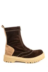 Bota tipo borcego de caña media, confeccionada en combinación de gamuza y cuero en tonos marrón oscuro y tostado. Presenta cierre frontal, costuras decorativas visibles y suela track de goma en color crema.