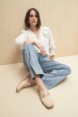 Jean de corte recto confeccionado en denim con spandex, de tiro medio y color azul claro. Presenta un tajo lateral en el ruedo de ambas piernas.