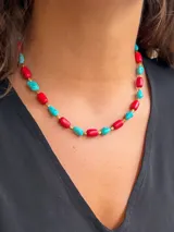 Collar corto tipo gargantilla compuesto por cuentas irregulares de color rojo y turquesa, separadas por pequeñas cuentas doradas.