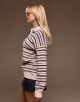 Sweater de punto con diseño de rayas horizontales en tonos rosa y azul marino. Presenta cuello tipo polo con cierre de botones, mangas largas con puños acanalados y un calce relajado.