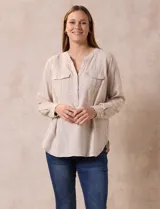 Blusa color beige de lino, marca Dash. Cuello a la base, escote en V y abertura con botones. Delantera con bolsillos. Largo de manga regulable con presilla y botón.