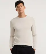 Suéter de manga larga y cuello redondo, color beige claro, de corte regular y tejido liso.