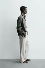 Pantalón de corte regular fit confeccionado en mezcla de algodón y lino. Presenta cintura elástica con cordón ajustable, cierre frontal con cremallera y botón, bolsillos laterales y bolsillo trasero de vivo con botón.